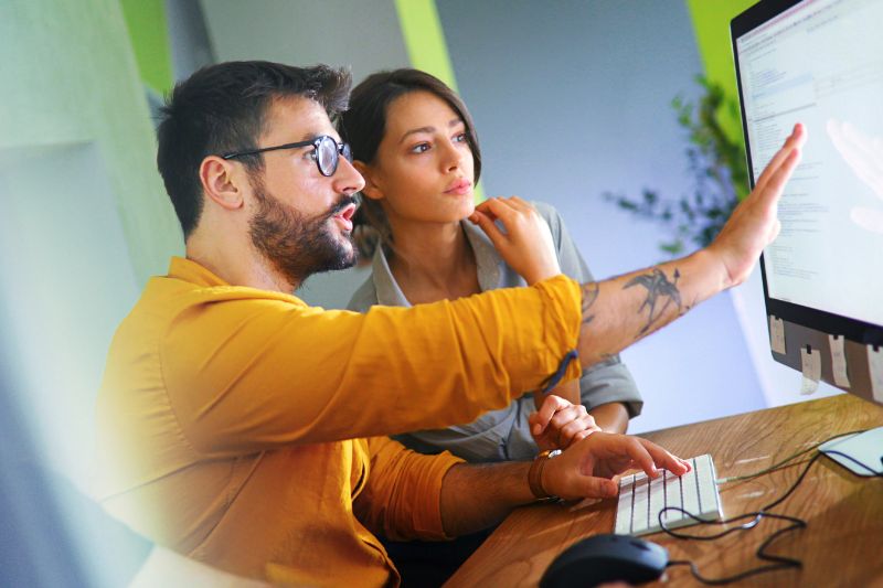 Two professionals reviewing data privacy compliance on a computer, illustrating the role of a DPO